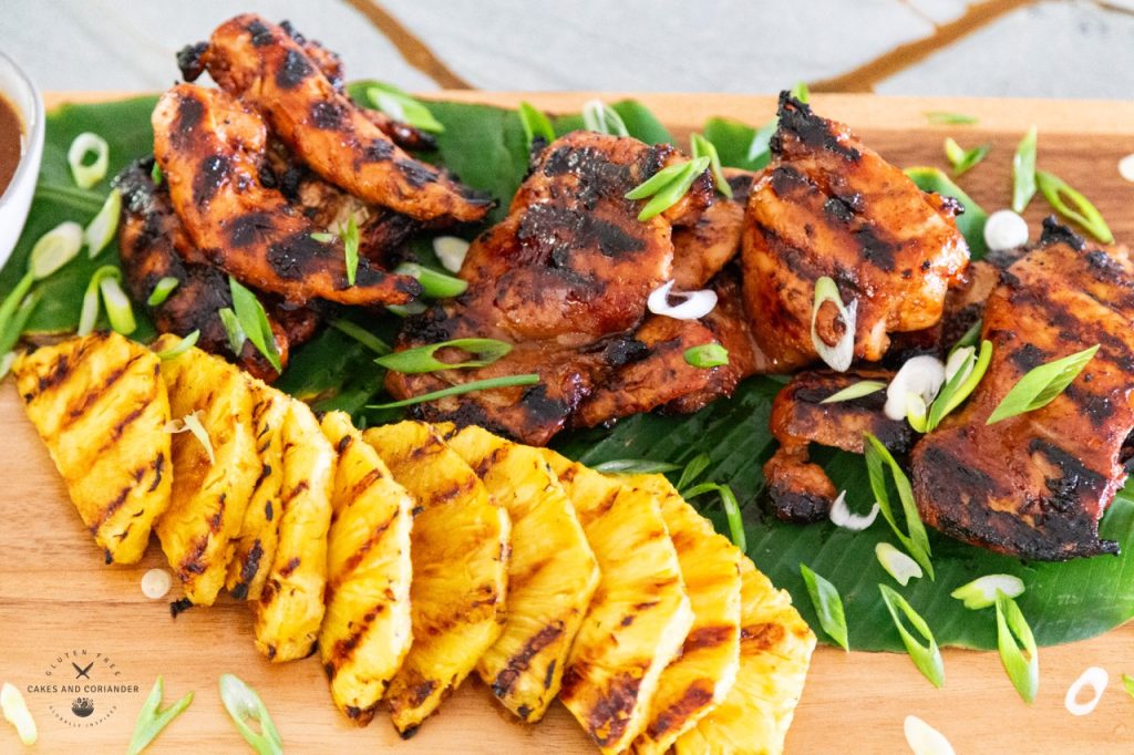 Grilled Hawaiian Chicken with Grilled Pineapple on wood board with banana leaf