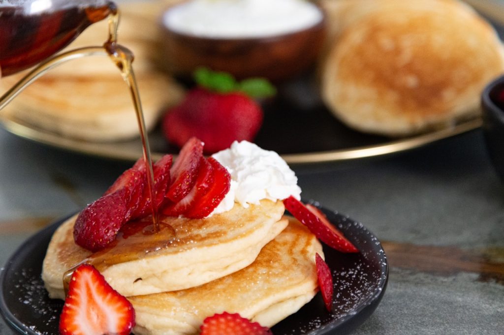 Wonderful Fluffy Buttermilk Gluten Free Pancakes with strawberries and whipped cream with syrup