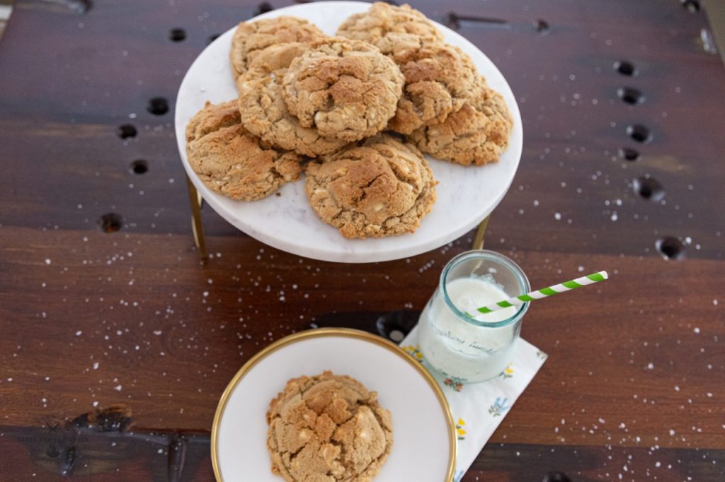 Levain Inspired Lemon White Chip Cookies- Gluten Free on a cake plate with glass of milk