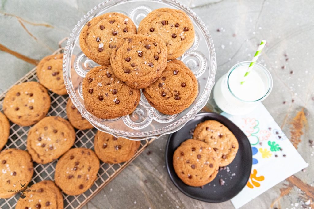 Gluten Free Crispy Chocolate Chip Cookies on a crystal tray with milk